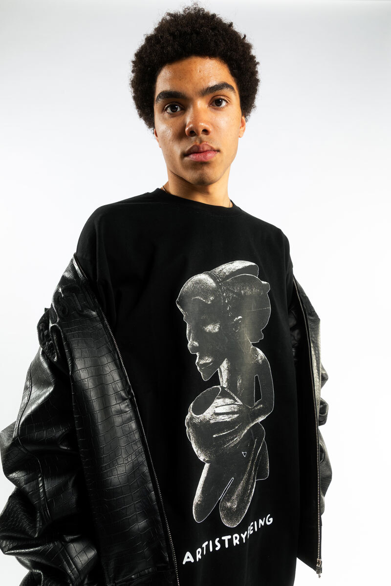 portrait of a man in front of a white background, wearing a black jacket and a shirt underneath