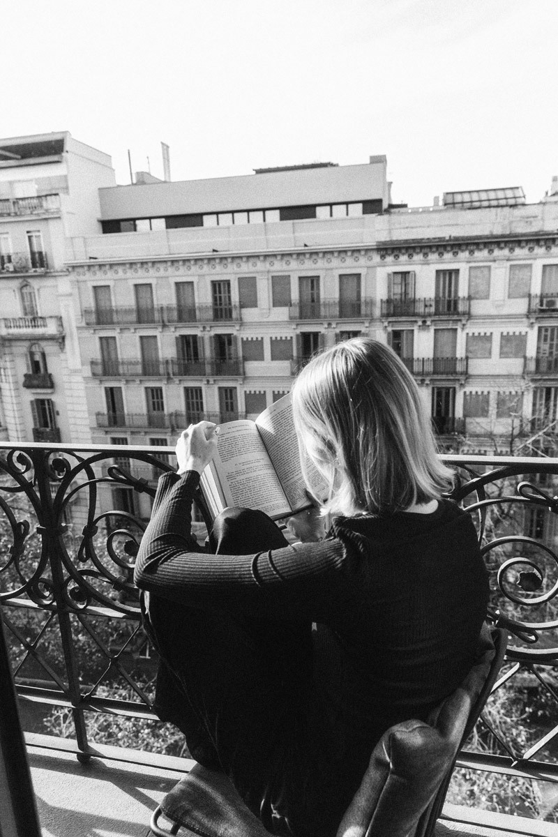 woman reading a book on the balcony