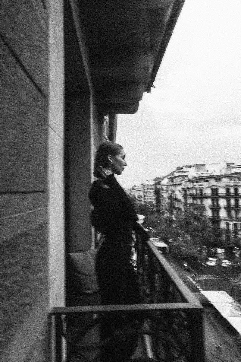 woman standing on a balcony, black and white photo