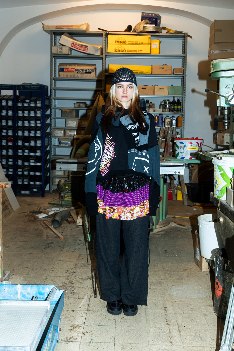 girl wearing a designer outfit, standing in the middle of a workshop