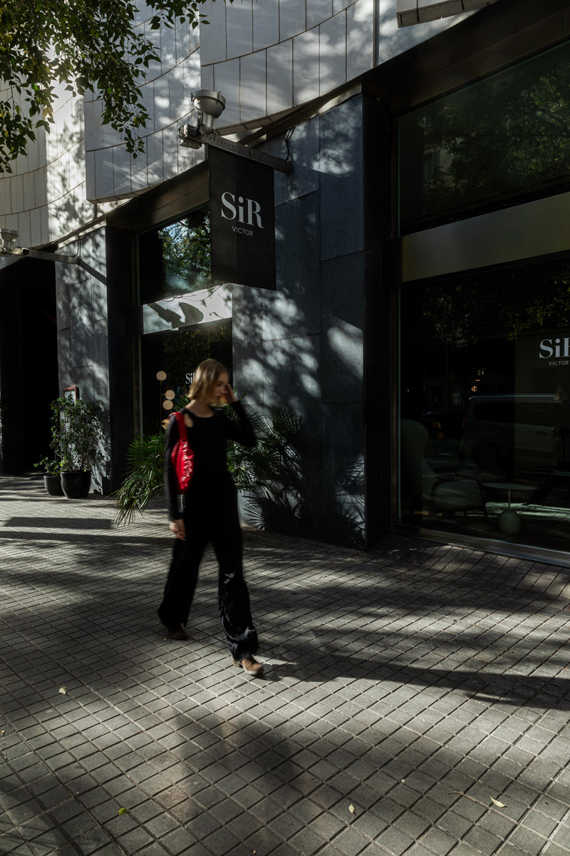 woman walking in front of a hotel
